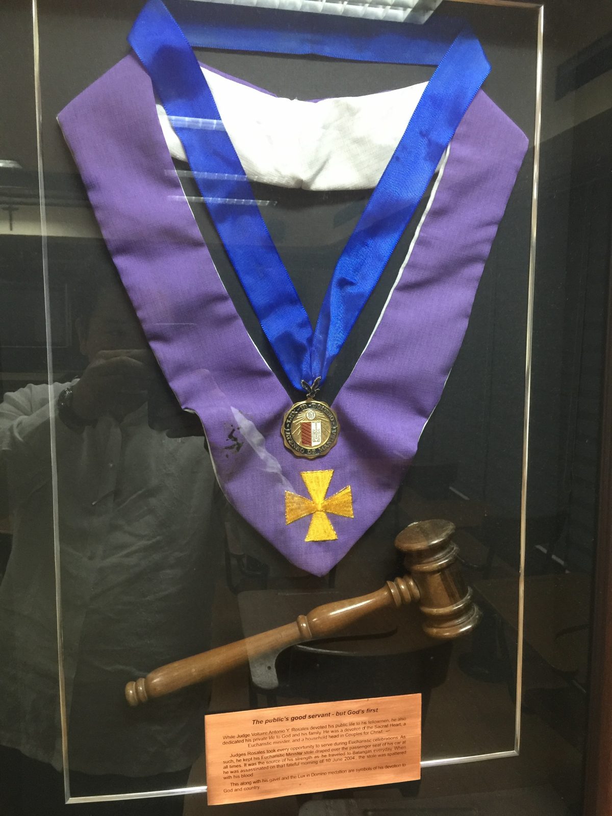His purple Eucharistic minister’s stole, Lux-in-Domino medallion, and gavel, framed